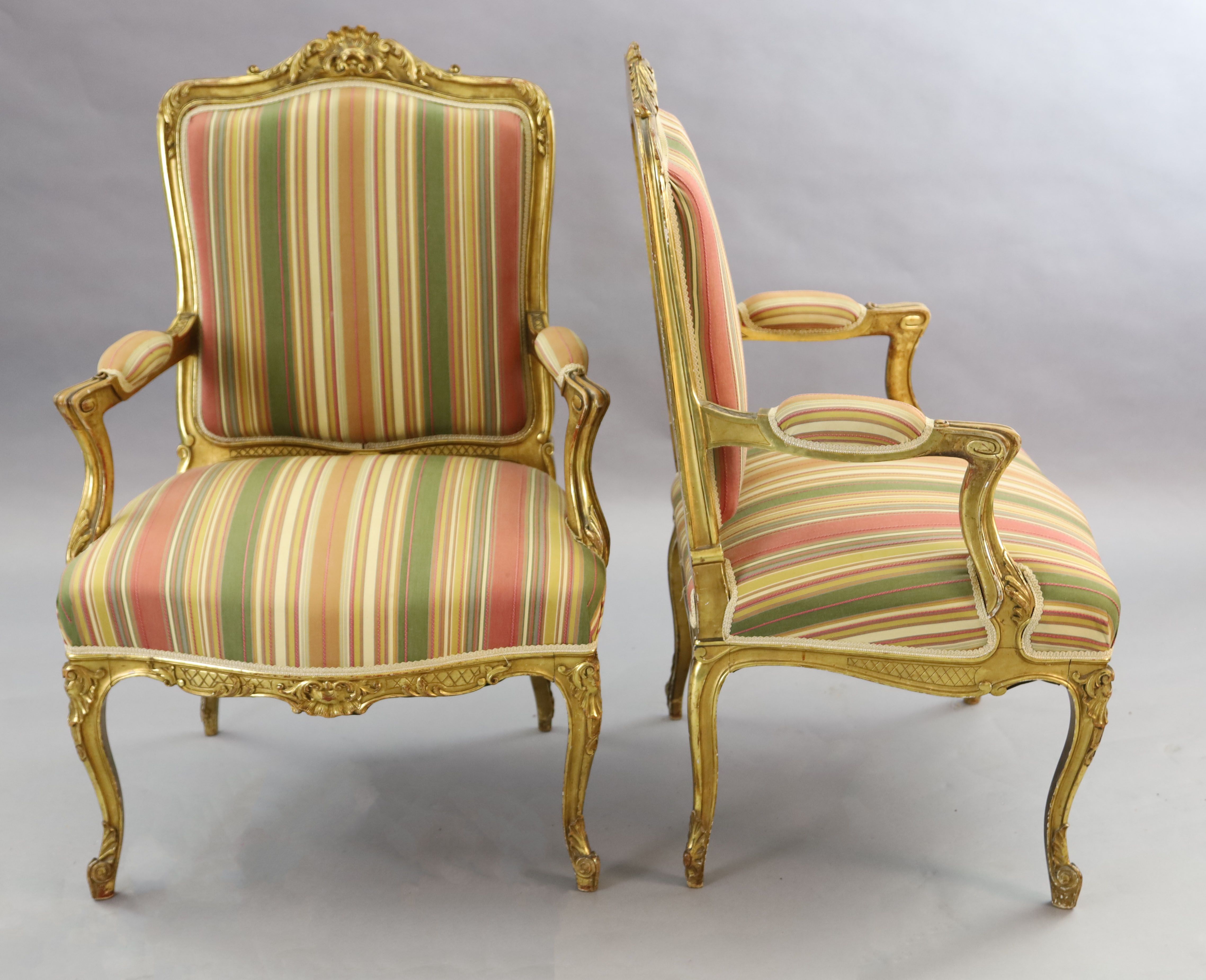 A pair of French gilt beech fauteuils, W.2ft 3in. D.2ft 1in. H.3ft 5in.